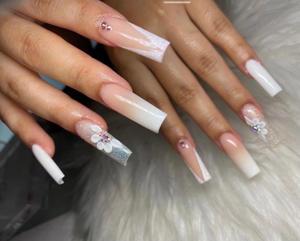 Long nude-to-white ombre nails with flower accents, done at Miyu Nails & Spa